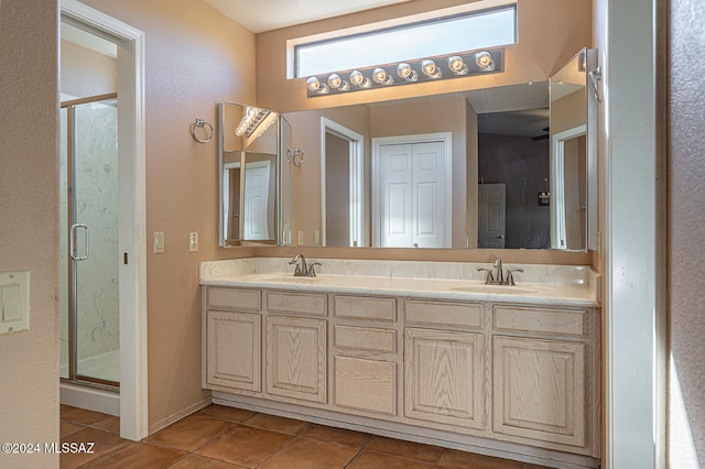 bathroom featuring tile patterned floors, vanity, and a shower with door