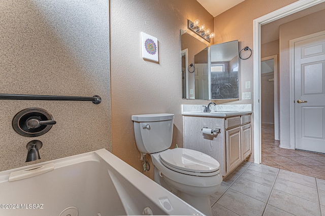 bathroom with tile patterned floors, vanity, toilet, and a tub to relax in