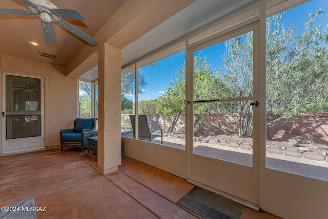 unfurnished sunroom with ceiling fan and plenty of natural light