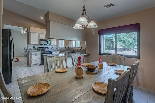 tiled dining area featuring ceiling fan and vaulted ceiling