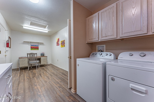 washroom featuring cabinets, a textured ceiling, washing machine and dryer, and dark hardwood / wood-style flooring