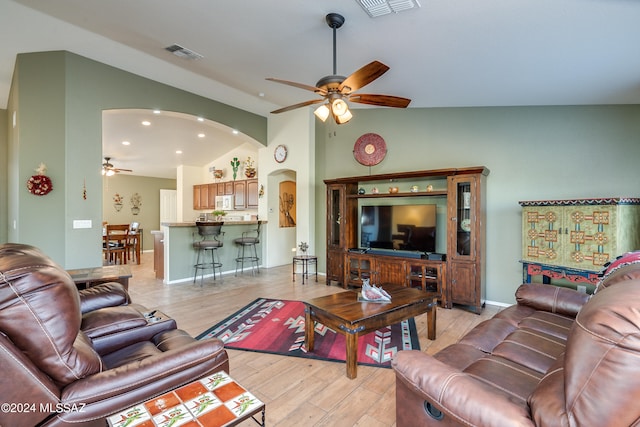 living room with lofted ceiling, light wood-type flooring, and ceiling fan