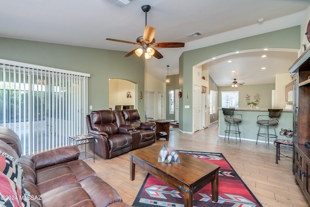 living room with light hardwood / wood-style floors, vaulted ceiling, and ceiling fan