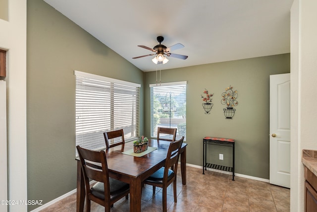 tiled dining room with lofted ceiling and ceiling fan