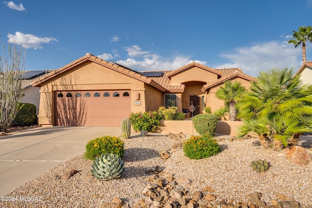 view of front of home with a garage and solar panels