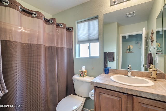 bathroom with walk in shower, vanity, and toilet