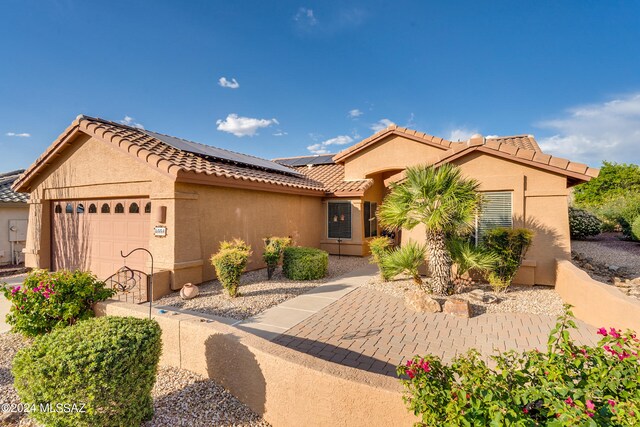 view of front of property with a garage and solar panels