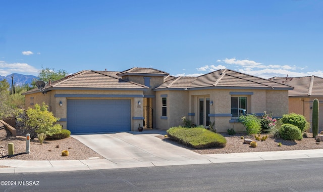 view of front of property with a mountain view and a garage