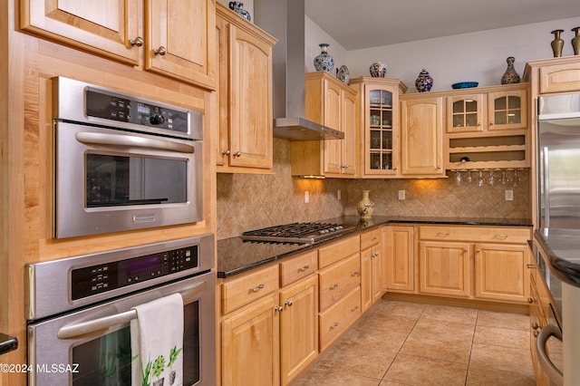 kitchen with backsplash, wall chimney range hood, light tile patterned flooring, and light brown cabinets