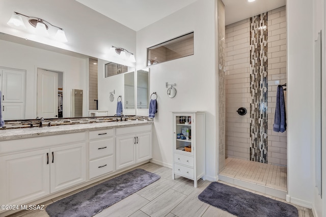 bathroom with vanity and a tile shower