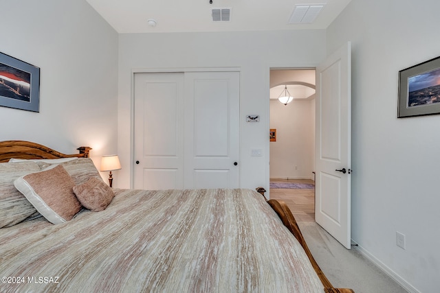 bedroom with light colored carpet and a closet