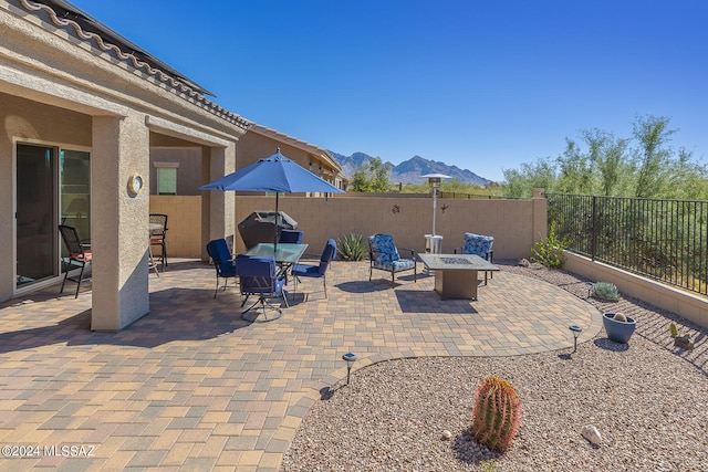 view of patio with an outdoor fire pit and a mountain view