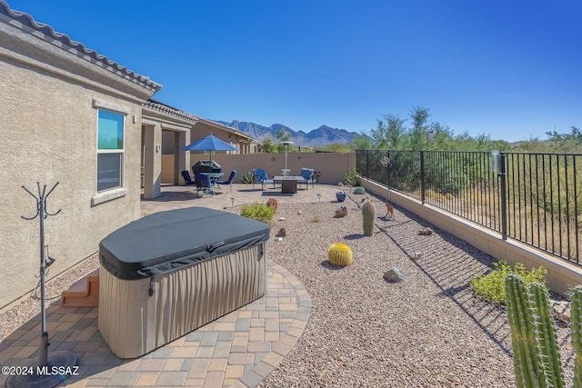 view of patio / terrace with a mountain view and a hot tub