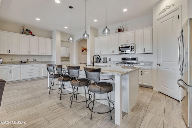 kitchen with white cabinetry, a kitchen island with sink, and appliances with stainless steel finishes