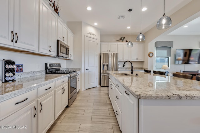 kitchen featuring sink, white cabinets, a kitchen island with sink, and stainless steel appliances