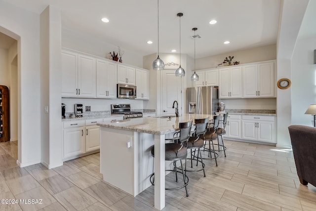 kitchen featuring white cabinetry, a kitchen island with sink, and appliances with stainless steel finishes