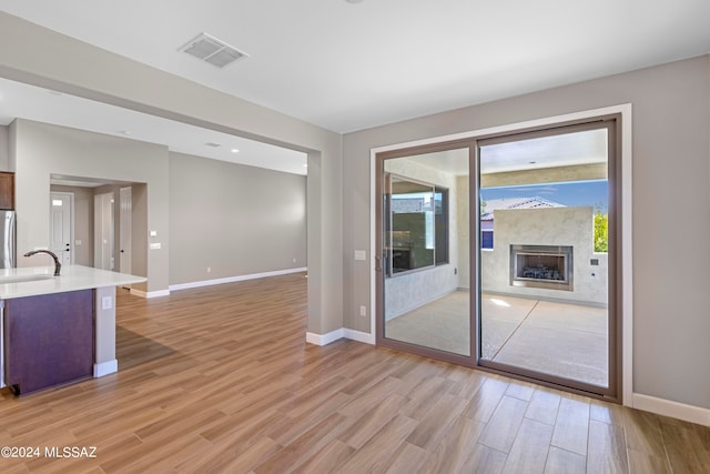 doorway to outside with sink and light hardwood / wood-style floors