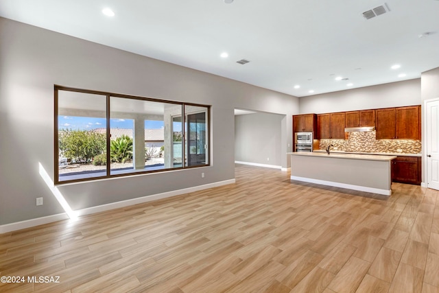 unfurnished living room with light wood-type flooring and sink