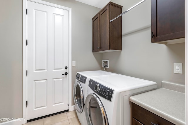 laundry room featuring independent washer and dryer, light tile patterned flooring, and cabinets