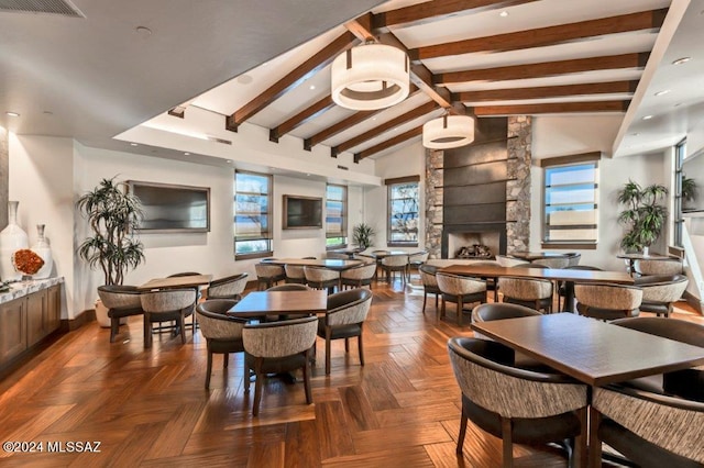 dining area featuring a fireplace, vaulted ceiling with beams, and dark parquet floors