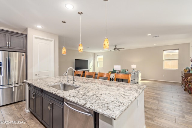 kitchen with appliances with stainless steel finishes, light hardwood / wood-style flooring, sink, and plenty of natural light