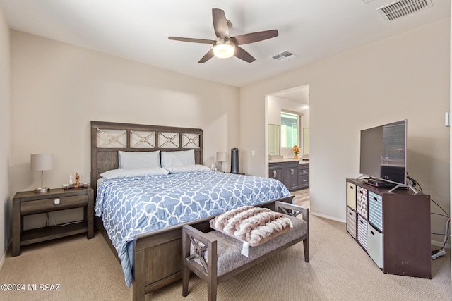 bedroom with light carpet, ensuite bathroom, and ceiling fan