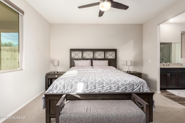 carpeted bedroom featuring sink, ensuite bath, and ceiling fan