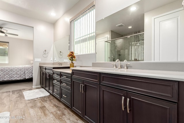 bathroom featuring ceiling fan, vanity, and a shower with door