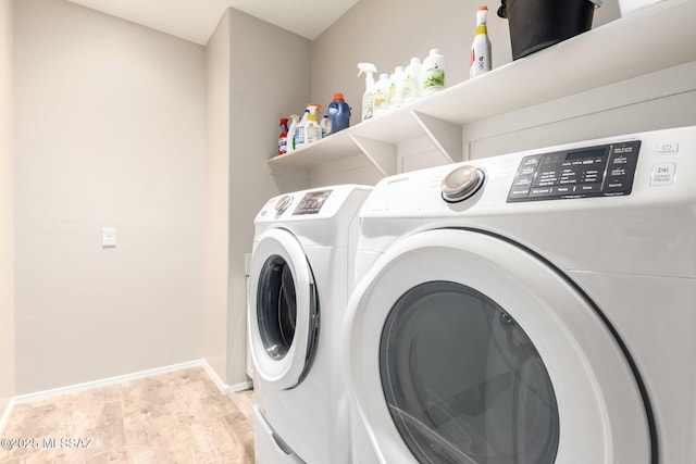 clothes washing area with separate washer and dryer and light wood-type flooring