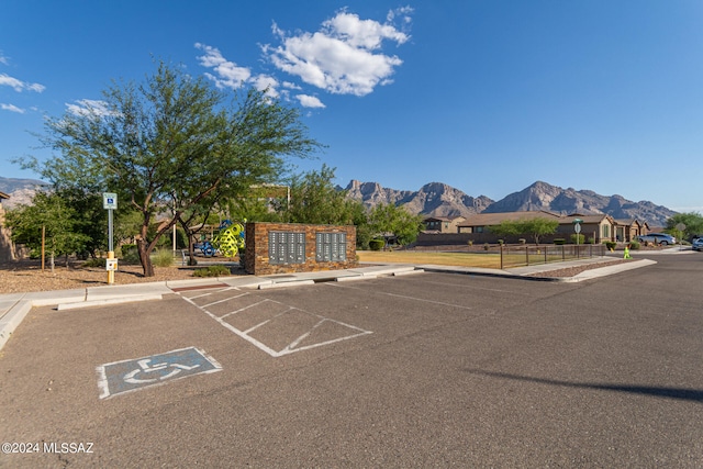 view of parking / parking lot featuring a mountain view and mail boxes