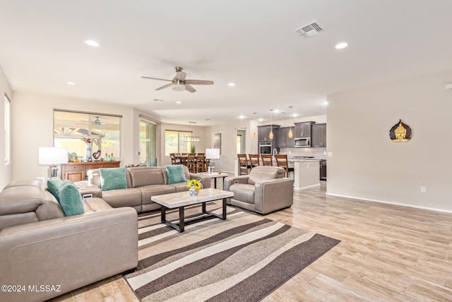 living room with light wood-type flooring and ceiling fan