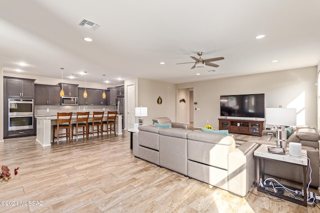 living room with light wood-type flooring and ceiling fan