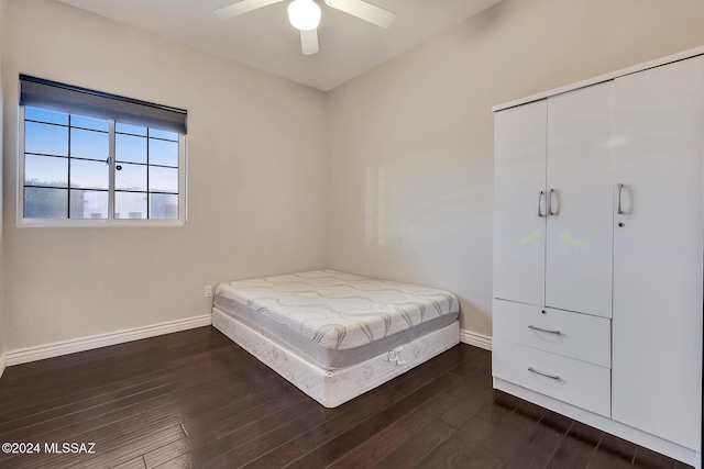 bedroom with ceiling fan, a closet, and dark wood-type flooring