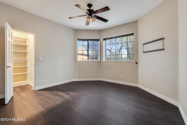 empty room with ceiling fan and dark hardwood / wood-style flooring