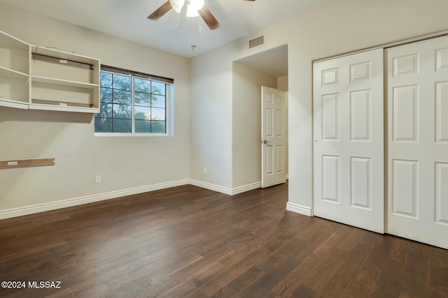 unfurnished bedroom featuring ceiling fan, dark hardwood / wood-style flooring, and a closet