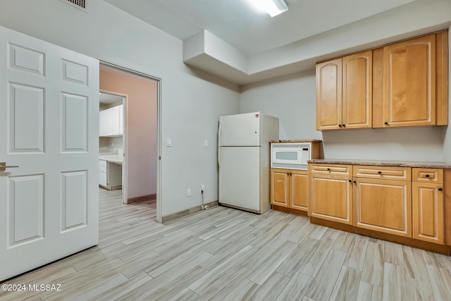 kitchen featuring white appliances and light hardwood / wood-style floors