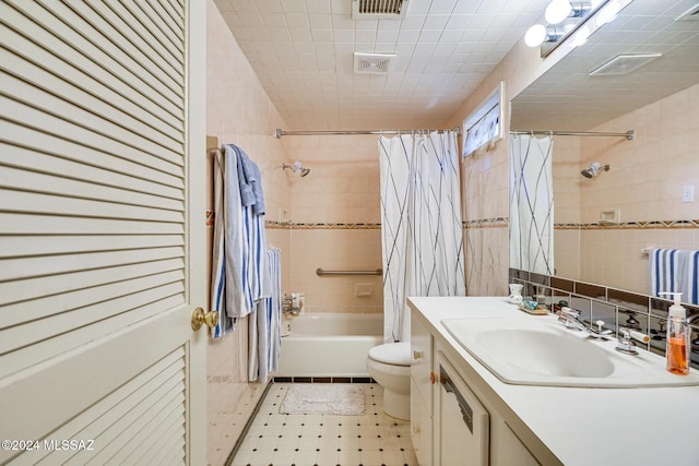 full bathroom with shower / bath combo, vanity, toilet, and tile walls