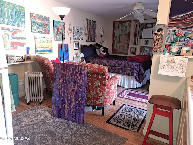 bedroom featuring wood finished floors and radiator heating unit