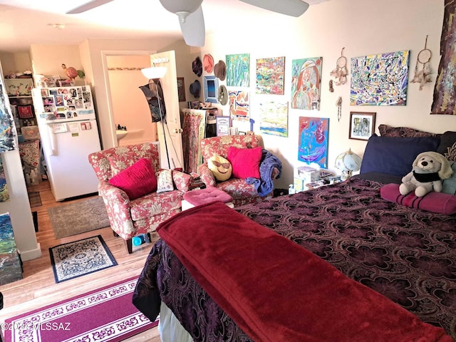 bedroom featuring hardwood / wood-style floors, white fridge, and ceiling fan