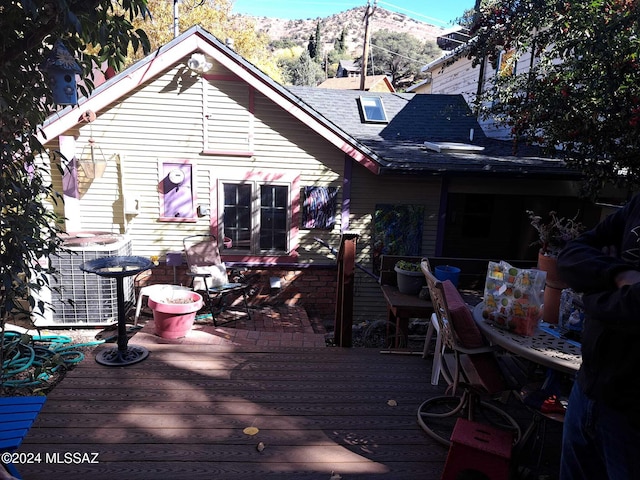 deck featuring outdoor dining area and a mountain view
