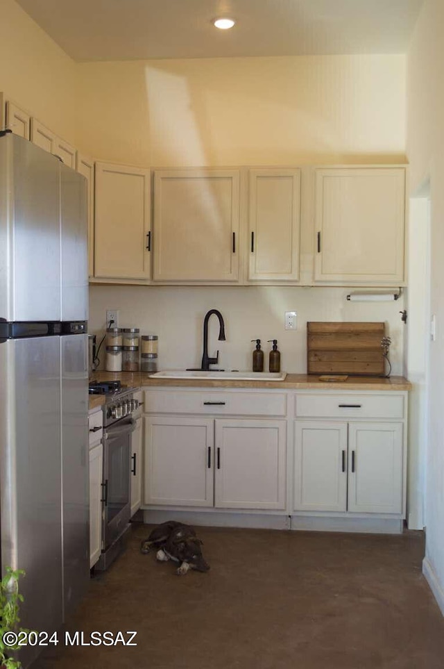 kitchen featuring appliances with stainless steel finishes, white cabinetry, and sink