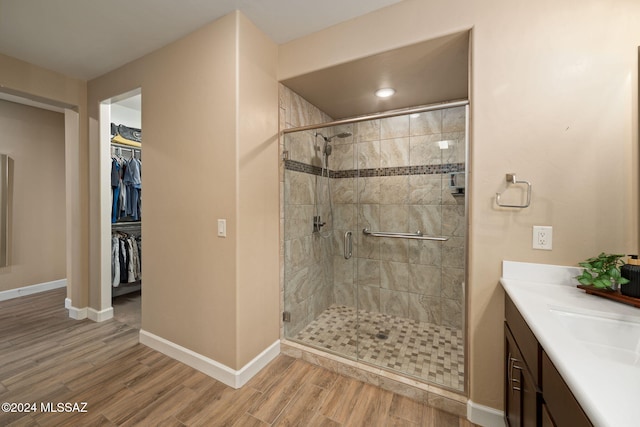 bathroom with hardwood / wood-style flooring, vanity, and walk in shower