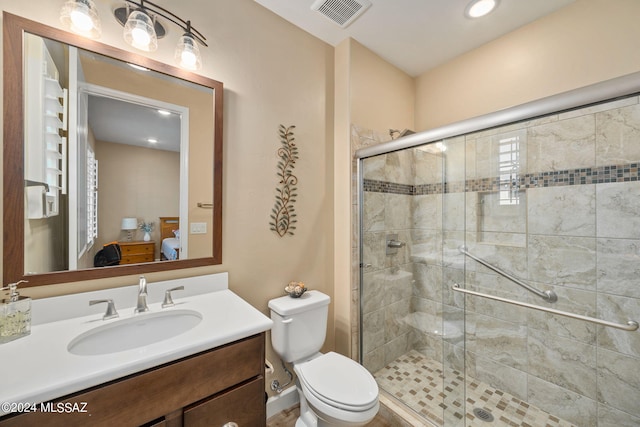 bathroom with vanity, a shower with shower door, and toilet