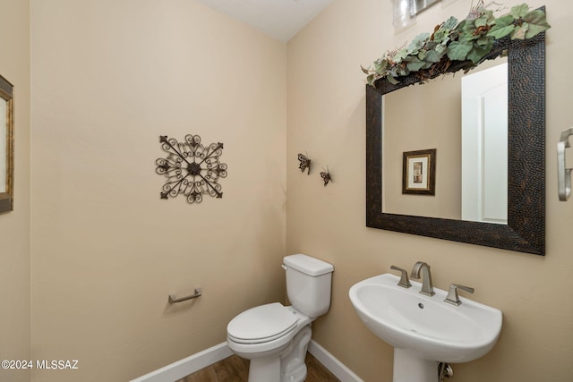 bathroom featuring hardwood / wood-style flooring, toilet, and sink