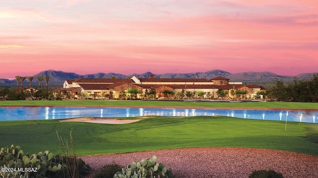 view of property's community featuring a water and mountain view and a lawn