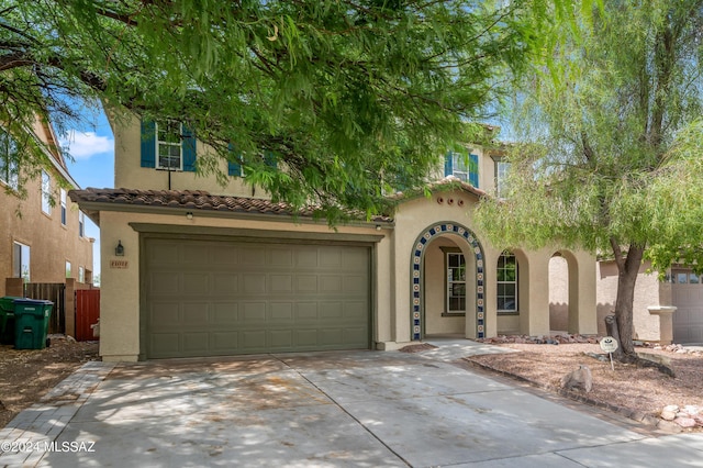 view of front of house featuring fence, driveway, a tiled roof, and stucco siding