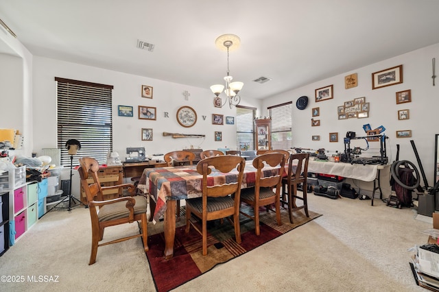 dining room with visible vents, light carpet, and an inviting chandelier