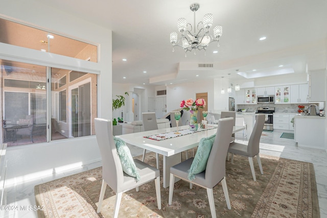 dining space featuring sink and an inviting chandelier