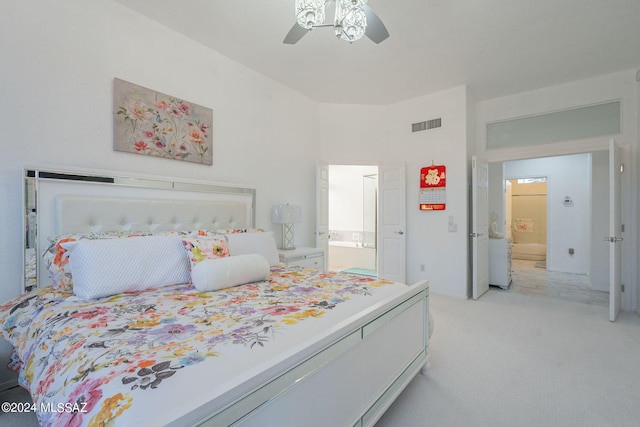 carpeted bedroom with ensuite bath and ceiling fan