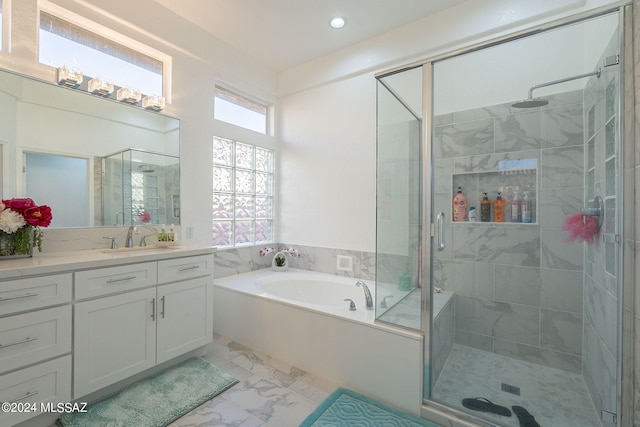 bathroom featuring vanity and independent shower and bath